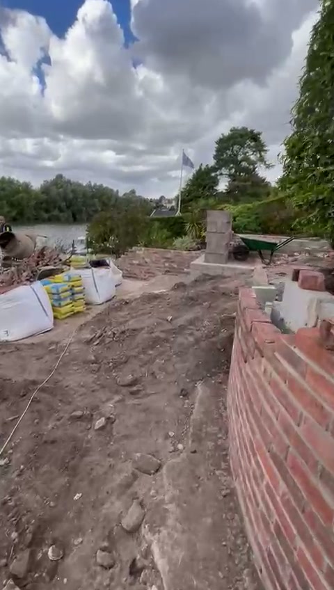 New brick retaining wall built along the terrace with the river behind