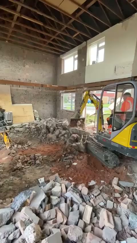 Mini excavator breaking out internal walls during a bungalow extension strip-out