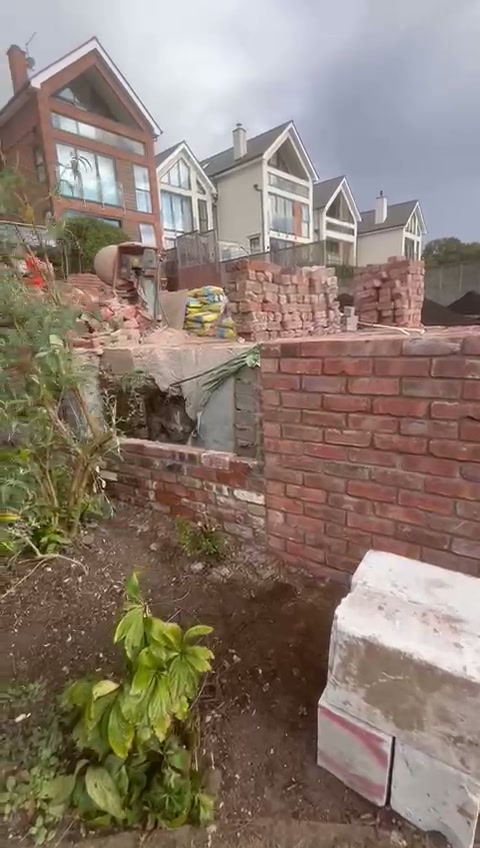 Brick retaining wall rebuilt with the houses and river beyond