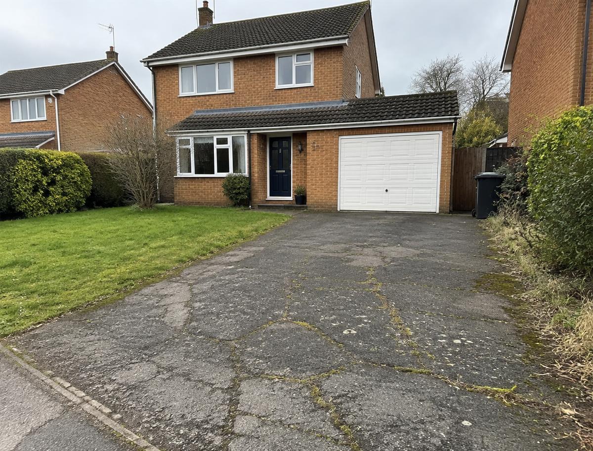 Cracked tarmac driveway with weeds before the resin work started
