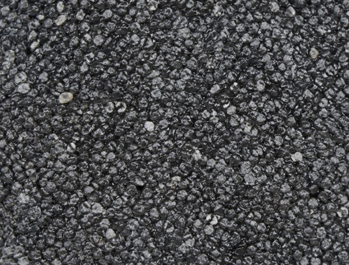Close-up texture of the cured dark grey resin-bound gravel surface